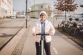 A woman has rented an electric scooter and is planning to ride on a sunny winter day in Denmark, Copenhagen. Ecological clean