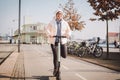 A woman has rented an electric scooter and is planning to ride on a sunny winter day in Denmark, Copenhagen. Ecological clean