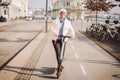 A woman has rented an electric scooter and is planning to ride on a sunny winter day in Denmark, Copenhagen. Ecological clean