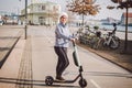 A woman has rented an electric scooter and is planning to ride on a sunny winter day in Denmark, Copenhagen. Ecological clean