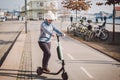 A woman has rented an electric scooter and is planning to ride on a sunny winter day in Denmark, Copenhagen. Ecological clean