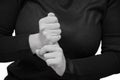 The woman has sore finger, she holds on to him with her healthy hand. Horizontal, black and white close-up photo