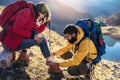 A woman has sprained her ankle while hiking, her friend uses the first aid kit Royalty Free Stock Photo