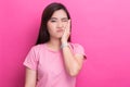 Woman has toothache over pink background