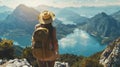 woman with a hat and backpack looking at the mountains and lake from the top of a mountain Royalty Free Stock Photo