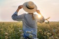 Woman with hat in beautiful blossoming buckwheat field