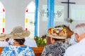 Woman in a hat in a catholic church in the service, Rarotonga, Aitutaki, Cook Islands. With selective focus. Back view