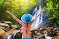 Woman in hat enjoying sun holidays at the waterfall in Thailand