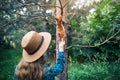 Woman in Hat feeding squirrel in forest