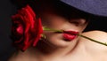 Woman In Hat and Flower. girl holding Red Rose in her mouth Royalty Free Stock Photo