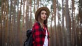 Woman in a hat with a hiking backpack in the forest. Concept hike, tourism.