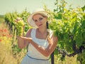 Woman in hat holding a ripe bunch of grapes on a Sunny day. Royalty Free Stock Photo