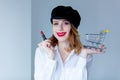 Woman in hat with lipstick for makeup and shopping cart Royalty Free Stock Photo