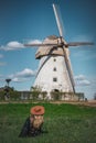 Woman in hat looking at old wildmill building, summer sunny day