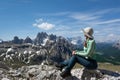 The woman in the hat looks at the mountains during hiking in Dolomites Royalty Free Stock Photo