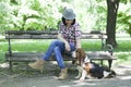 Woman with a hat in the park enjoying with her dear dog