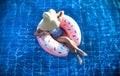 A woman in a hat relaxes on an inflatable circle in the pool Royalty Free Stock Photo