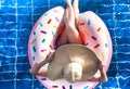 A woman in a hat relaxes on an inflatable circle in the pool Royalty Free Stock Photo