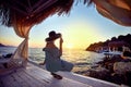 Woman In Hat Relaxing By The Sea In A Luxurious Beachfront Hotel Resort At Sunset Enjoying Perfect Beach Holiday Vacation In