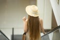 Woman in hat riding escalator in shopping mall Royalty Free Stock Photo