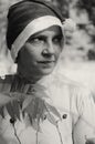 A woman in a hat of Santaclaus with a sly evil face among the autumn foliage as a harbinger of the coming winter.