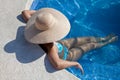 Woman with hat sitting in the pool