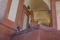 Woman in hat stadning on balcony surrounded by arches and plaster walls Royalty Free Stock Photo