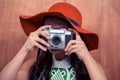 Woman with hat taking photograph with camera