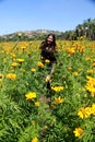 Woman with hat walks in cultivation field of Cempasuchil flower, flower for day of the dead in Mexico Royalty Free Stock Photo