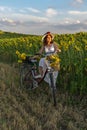 A woman in a hat and a white dress with a bicycle Royalty Free Stock Photo