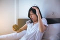 Asian woman hates getting stressed waking up early,Female stretching her hand to ringing alarm to turn off alarm clock