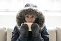 Woman have cold drink coffee on the sofa at home with winter coat