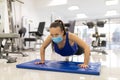 Woman have indoor training in gim with medical facemask push-ups. Female breathes deeply stock photo Royalty Free Stock Photo