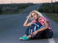 Woman with haversack sitting on the road