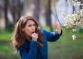 Woman having allergy symptoms in front of blooming tree Royalty Free Stock Photo