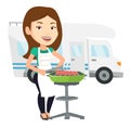 Woman having barbecue in front of camper van.