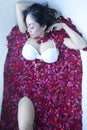 Woman having a bath with rose petals Royalty Free Stock Photo