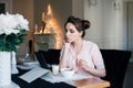 Woman having Breakfast with cereals and milk and looks at tablet Royalty Free Stock Photo