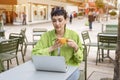 woman having coffee at street cafe outside, talking on the laptop and having fun time. lifestyle concept Royalty Free Stock Photo