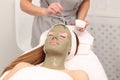 Woman having cosmetic facial seaweed treatment in spa
