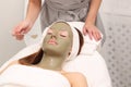 Woman having cosmetic facial seaweed treatment in spa