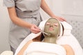 Woman having cosmetic facial seaweed treatment in spa