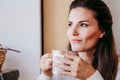 woman having a cup of tea at home during breakfast. Cute golden retriever dog besides. Healthy breakfast with fruits and sweets. Royalty Free Stock Photo