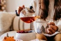 woman having a cup of tea at home during breakfast. Cute golden retriever dog besides. Healthy breakfast with fruits and sweets. Royalty Free Stock Photo