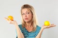 Woman having doubts between lemon and orange for beauty diet