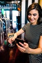 Woman having a drink and using smartphone Royalty Free Stock Photo