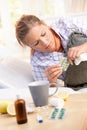 Woman having flu taking medicines in bed Royalty Free Stock Photo
