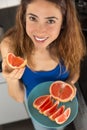 Woman having freshly cut grapefruit slices