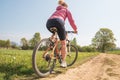 Woman having fun by riding mountain bike on country road in a sunny day, countryside landscape, fitness wellbeing sport in nature Royalty Free Stock Photo