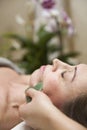 Woman having an gua sha facial massage with natural jade stone massager
